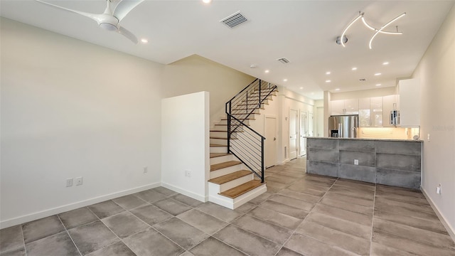 stairs with recessed lighting, visible vents, ceiling fan, and baseboards