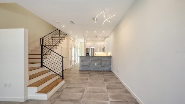 staircase featuring baseboards, visible vents, and recessed lighting