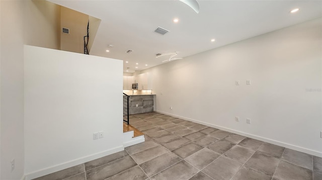 unfurnished living room featuring baseboards, visible vents, and recessed lighting