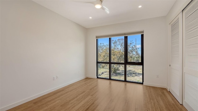 unfurnished bedroom featuring light wood finished floors, a closet, recessed lighting, and baseboards