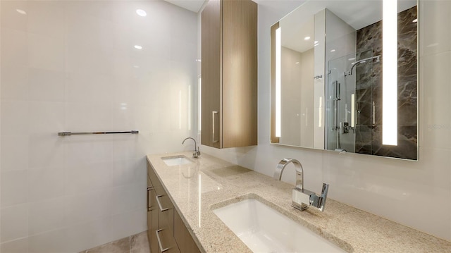 bathroom with a walk in shower, double vanity, and a sink