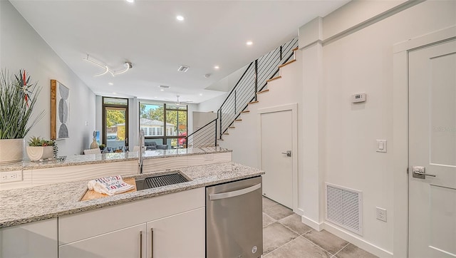 kitchen with white cabinetry, sink, dishwasher, and light stone countertops