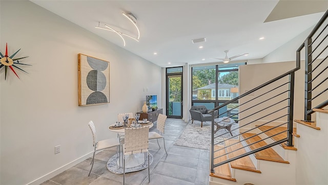 dining space with ceiling fan and a wall of windows