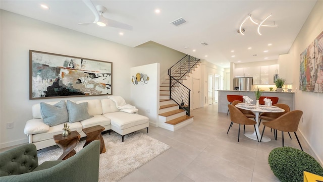 living area with light tile patterned floors, visible vents, recessed lighting, and stairs