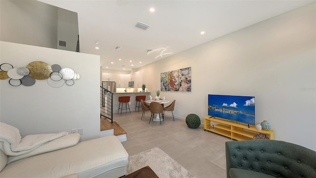 living room featuring recessed lighting, visible vents, and stairway