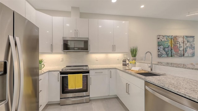 kitchen with white cabinets, backsplash, appliances with stainless steel finishes, and a sink