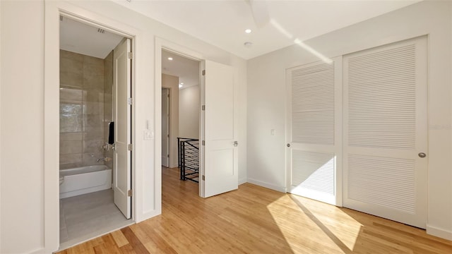 unfurnished bedroom with baseboards, light wood finished floors, recessed lighting, a closet, and connected bathroom