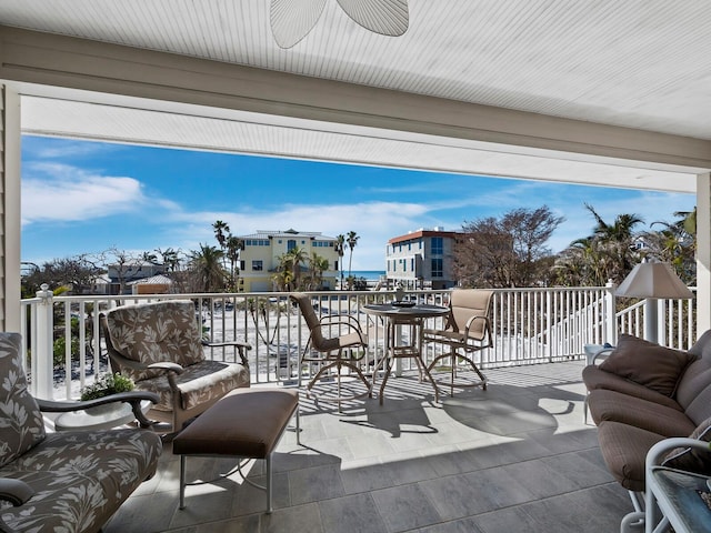 view of patio / terrace with a balcony, ceiling fan, and a water view