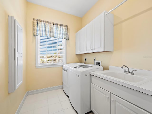 clothes washing area featuring sink, light tile patterned floors, cabinets, and washer and dryer