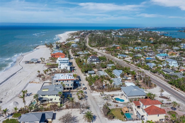 birds eye view of property featuring a water view and a beach view