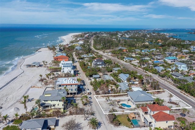 birds eye view of property with a water view and a beach view