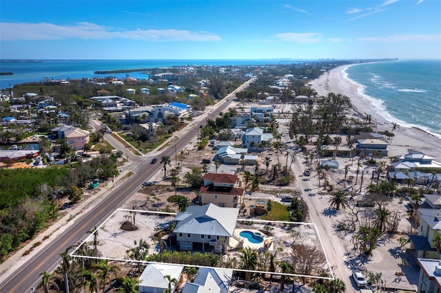 aerial view with a water view and a beach view