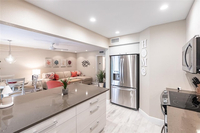 145 Avenida Messina Unit 3, Sarasota, FL 34242 - kitchen featuring stainless steel appliances, pendant lighting, light hardwood / wood-style floors, and white cabinets