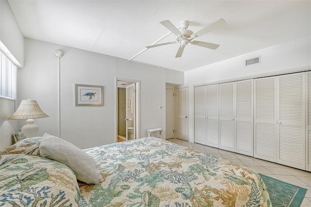 bedroom with ceiling fan, a closet, a textured ceiling, and light tile patterned floors