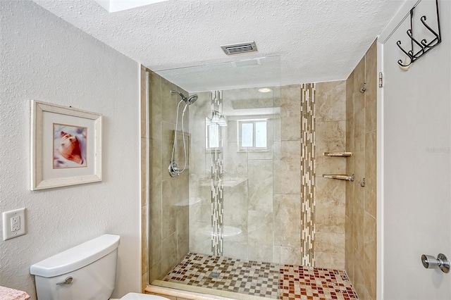 bathroom featuring toilet, a textured ceiling, and a shower with door