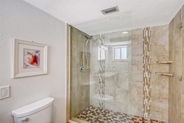 bathroom featuring toilet, a textured ceiling, and walk in shower