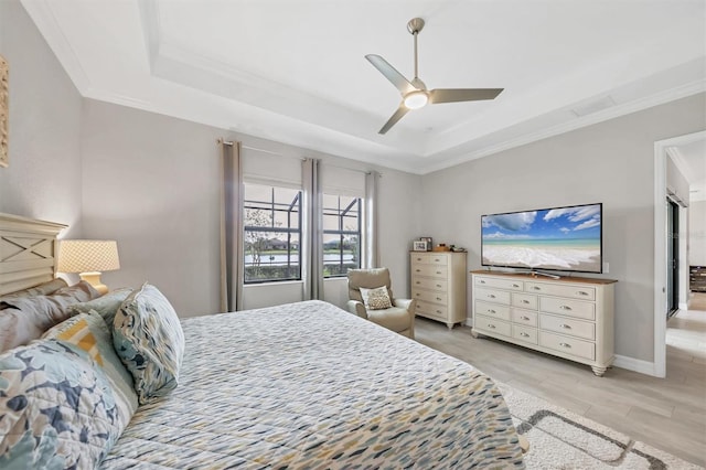 bedroom with ornamental molding, a raised ceiling, ceiling fan, and light hardwood / wood-style floors