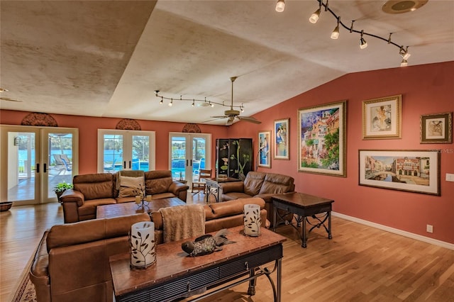 living room featuring ceiling fan, a healthy amount of sunlight, light hardwood / wood-style floors, and french doors