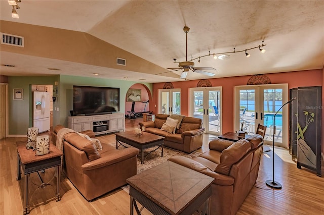 living room featuring ceiling fan, lofted ceiling, light hardwood / wood-style floors, and french doors