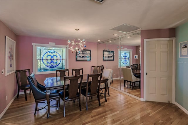 dining space featuring an inviting chandelier and hardwood / wood-style flooring