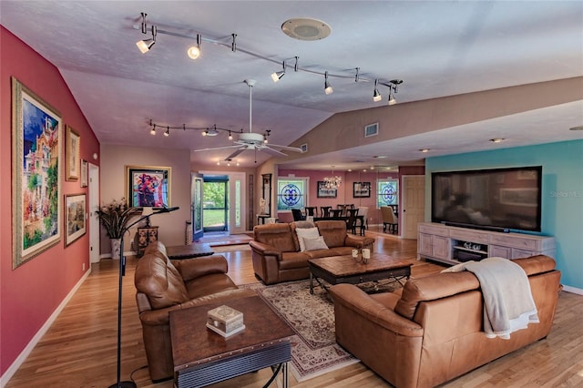 living room featuring ceiling fan, light hardwood / wood-style flooring, and vaulted ceiling