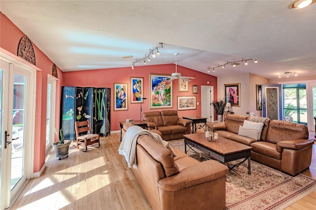 living room with lofted ceiling, light wood-type flooring, and ceiling fan