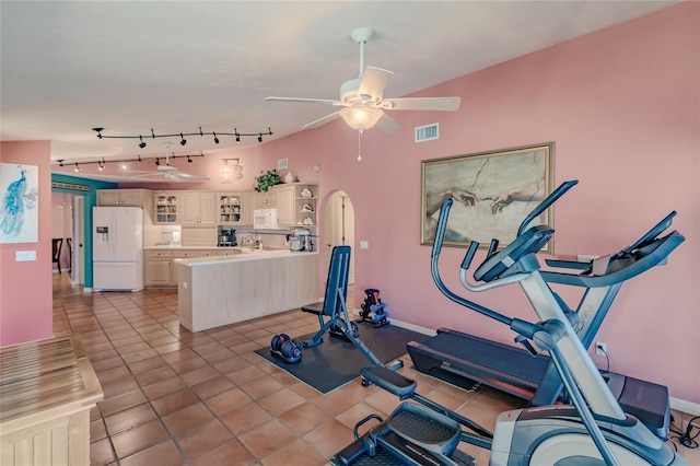 exercise area with ceiling fan and light tile patterned floors