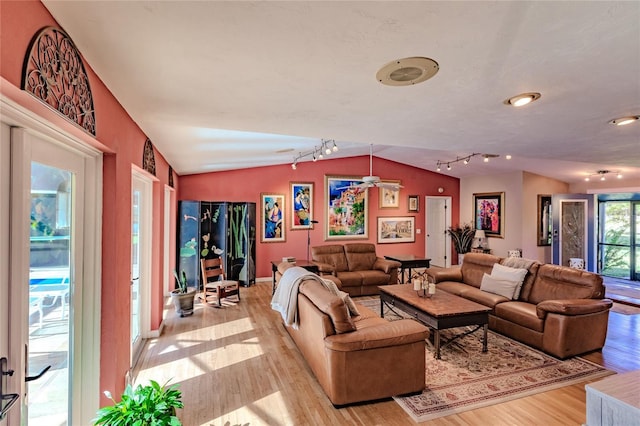 living room featuring light hardwood / wood-style floors, a chandelier, and vaulted ceiling