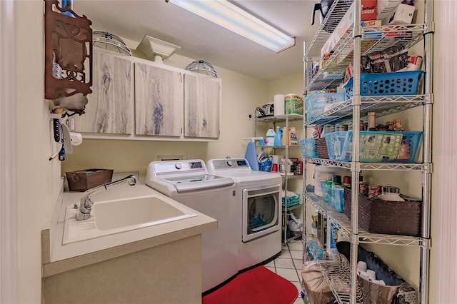 clothes washing area featuring cabinets, light tile patterned floors, sink, and washing machine and clothes dryer