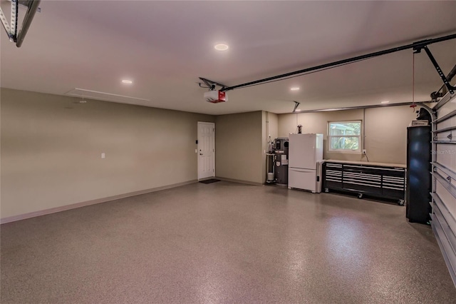 garage with electric water heater, white refrigerator, and a garage door opener