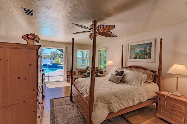 bedroom with ceiling fan, access to exterior, wood-type flooring, and crown molding