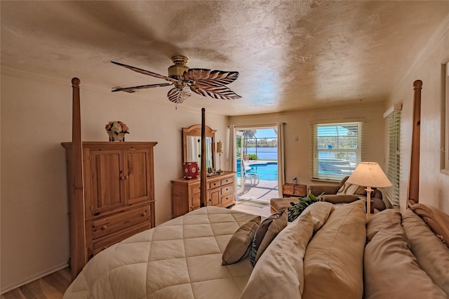 bedroom with ceiling fan, access to exterior, a textured ceiling, and light hardwood / wood-style flooring