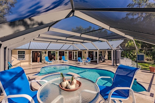 view of swimming pool with glass enclosure, a patio area, and a jacuzzi