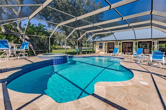 view of pool with an in ground hot tub, a patio area, and glass enclosure