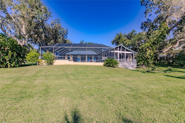 back of property featuring a lanai and a lawn