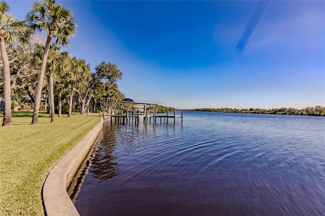 view of dock featuring a water view and a yard