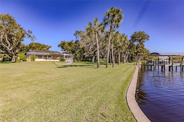 view of yard with a water view and a boat dock