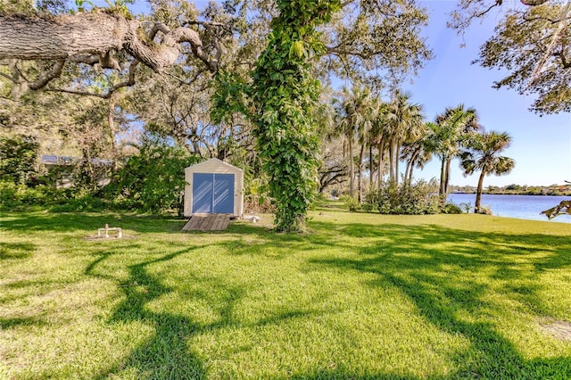 view of yard with a water view and a storage shed