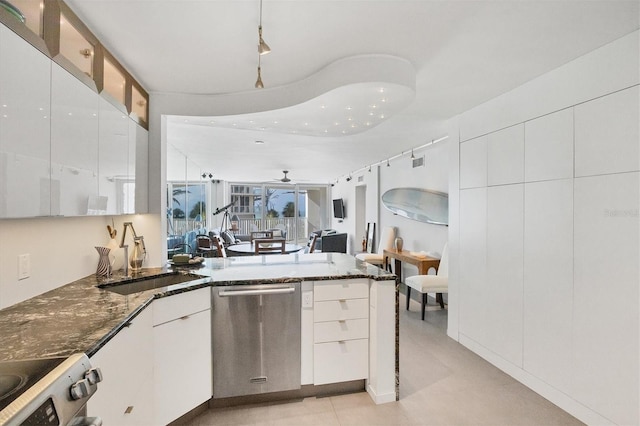 kitchen featuring white cabinets, ceiling fan, dishwasher, and dark stone counters