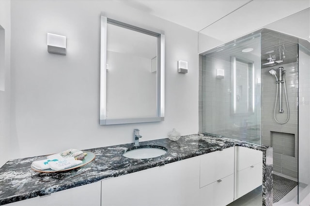 bathroom featuring tiled shower and vanity