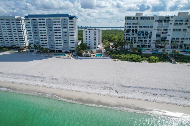 view of building exterior featuring a beach view and a water view