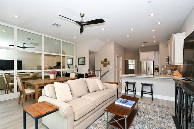 living room featuring ceiling fan and light wood-type flooring