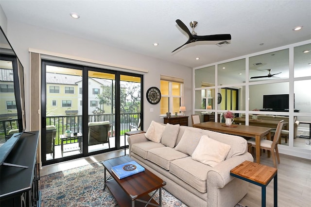 living room featuring ceiling fan and hardwood / wood-style floors