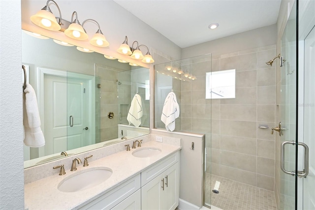 bathroom with a shower with shower door and vanity