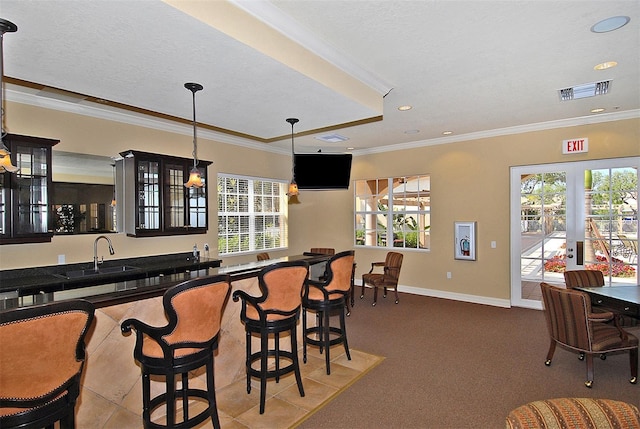 bar with a textured ceiling, french doors, sink, hanging light fixtures, and ornamental molding