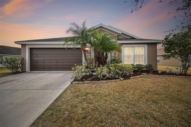 ranch-style house featuring a garage, concrete driveway, a yard, and stucco siding