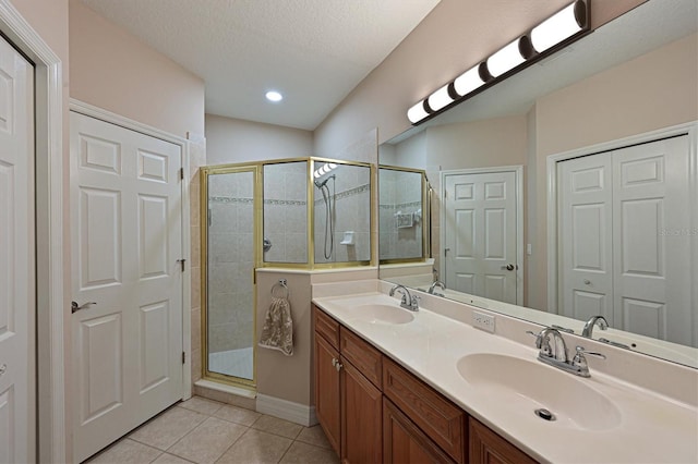 full bath featuring tile patterned flooring, a shower stall, and a sink