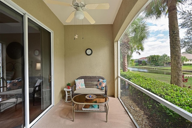 sunroom / solarium featuring ceiling fan and a water view