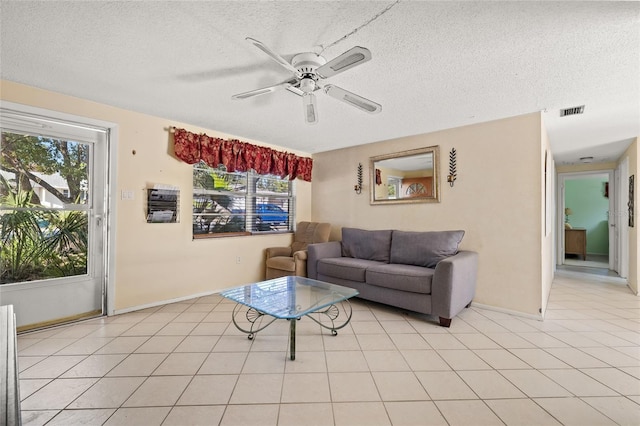 tiled living room with a textured ceiling and ceiling fan