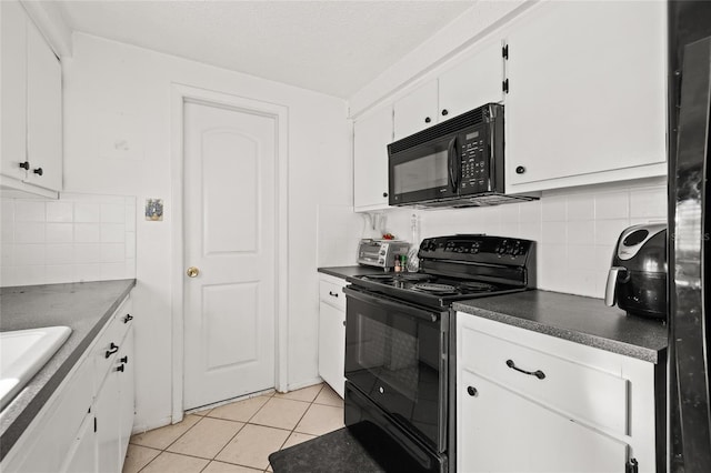 kitchen featuring decorative backsplash, light tile patterned flooring, white cabinets, and black appliances